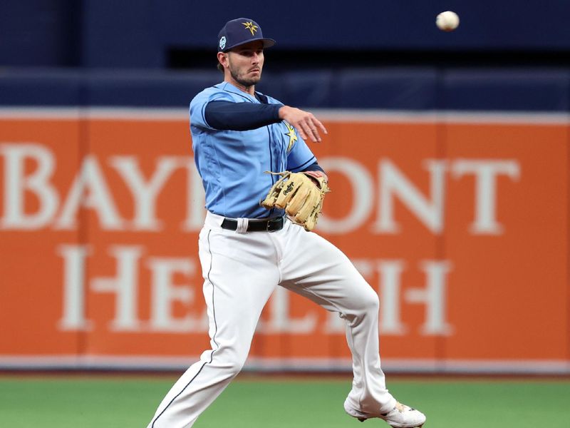 Mar 19, 2023; St. Petersburg, Florida, USA; (Editors Notes: Caption Correction) Tampa Bay Rays infielder Daniel Robertson (26) throws the ball for an out against the Toronto Blue Jays during the first inning at Tropicana Field. Mandatory Credit: Kim Klement-USA TODAY Sports