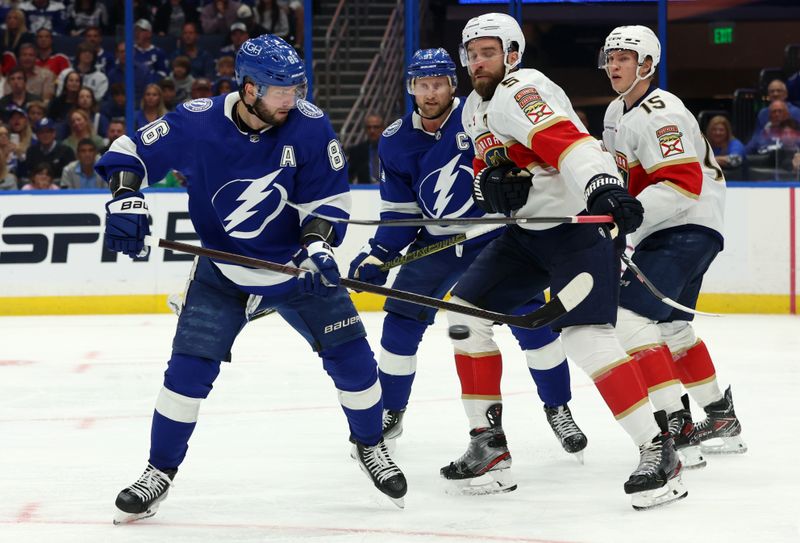 Apr 27, 2024; Tampa, Florida, USA; Tampa Bay Lightning right wing Nikita Kucherov (86) shoots as Florida Panthers defenseman Aaron Ekblad (5) and center Anton Lundell (15) defend  during the third period in game four of the first round of the 2024 Stanley Cup Playoffs at Amalie Arena. Mandatory Credit: Kim Klement Neitzel-USA TODAY Sports