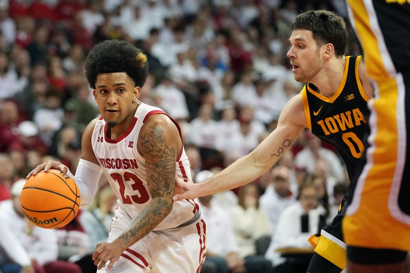 Feb 22, 2023; Madison, Wisconsin, USA; Wisconsin Badgers guard Chucky Hepburn (23) drives to the basket under coverage by Iowa Hawkeyes forward Filip Rebraca (0) during the second half at the Kohl Center. Mandatory Credit: Kayla Wolf-USA TODAY Sports