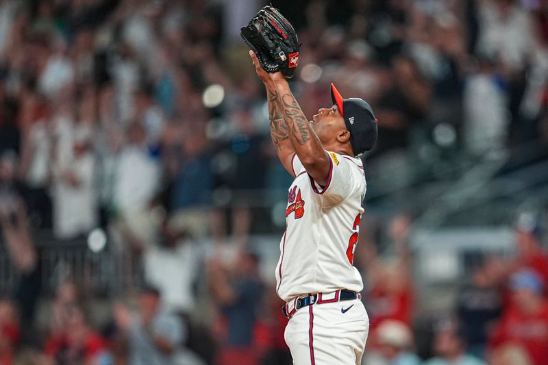 Aug 20, 2024; Cumberland, Georgia, USA; Atlanta Braves relief pitcher Raisel Iglesias (26)  reacts after the Braves defeated the Philadelphia Phillies at Truist Park. Mandatory Credit: Dale Zanine-USA TODAY Sports