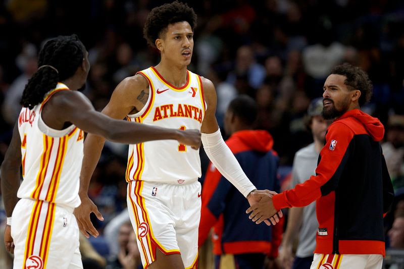 NEW ORLEANS, LOUISIANA - NOVEMBER 03: Jalen Johnson #1 of the Atlanta Hawks slaps hands with Keaton Wallace #2 and Trae Young #11 of the Atlanta Hawks after scoring in the fourth quarter against the New Orleans Pelicans at Smoothie King Center on November 03, 2024 in New Orleans, Louisiana. NOTE TO USER: User expressly acknowledges and agrees that, by downloading and or using this photograph, User is consenting to the terms and conditions of the Getty Images License Agreement. (Photo by Sean Gardner/Getty Images)