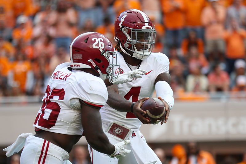 Oct 19, 2024; Knoxville, Tennessee, USA; Alabama Crimson Tide quarterback Jalen Milroe (4) hands the ball off to running back Jam Miller (26) against the Tennessee Volunteers during the second quarter at Neyland Stadium. Mandatory Credit: Randy Sartin-Imagn Images