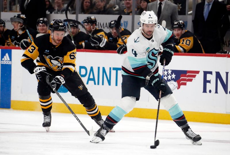 Jan 15, 2024; Pittsburgh, Pennsylvania, USA; Seattle Kraken defenseman Justin Schultz (4) handles the puck ahead of Pittsburgh Penguins left wing Radim Zohorna (63) during the first period at PPG Paints Arena. Mandatory Credit: Charles LeClaire-USA TODAY Sports