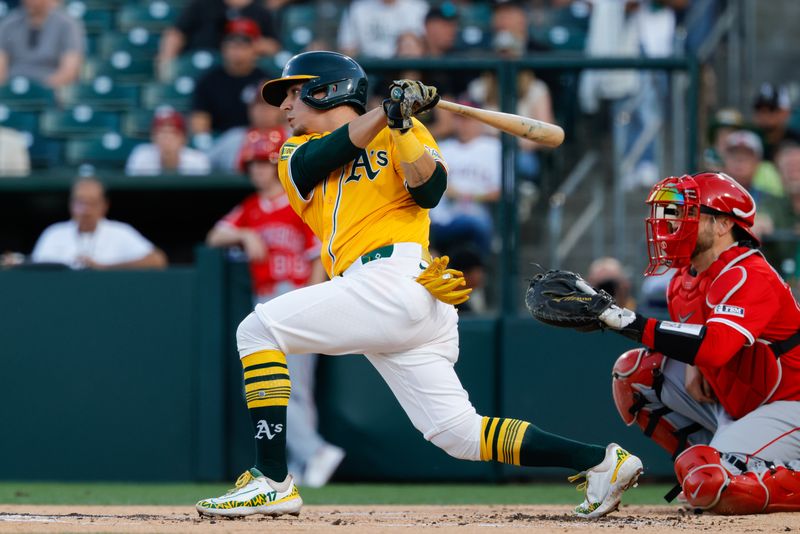 May 20, 2025; West Sacramento, California, USA; Athletics second baseman Luis Urías (17) hits an RBI single during the second inning against the Los Angeles Angels at Sutter Health Park. Mandatory Credit: Sergio Estrada-Imagn Images