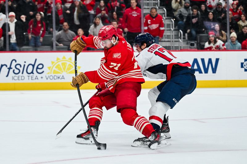 Dec 21, 2025; Detroit, Michigan, USA; Detroit Red Wings center Dylan Larkin (71) shoots as Washington Capitals center Dylan Strome (17) defends during overtime at Little Caesars Arena. Mandatory Credit: Tim Fuller-Imagn Images