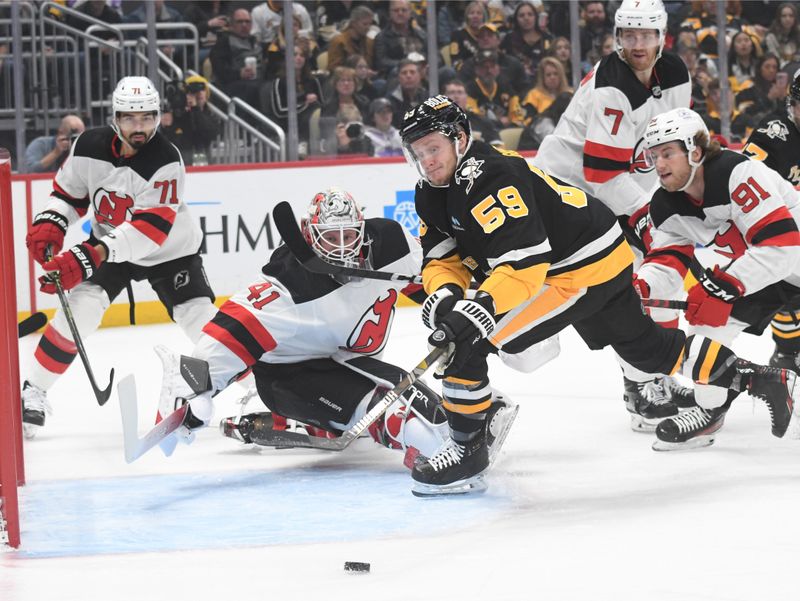 Nov 16, 2023; Pittsburgh, Pennsylvania, USA; Pittsburgh Penguins left wing Jake Guentzel (58) pressures New Jersey Devils goalie Vitek Vanecek (41) during the first period at PPG Paints Arena. Mandatory Credit: Philip G. Pavely-USA TODAY Sports