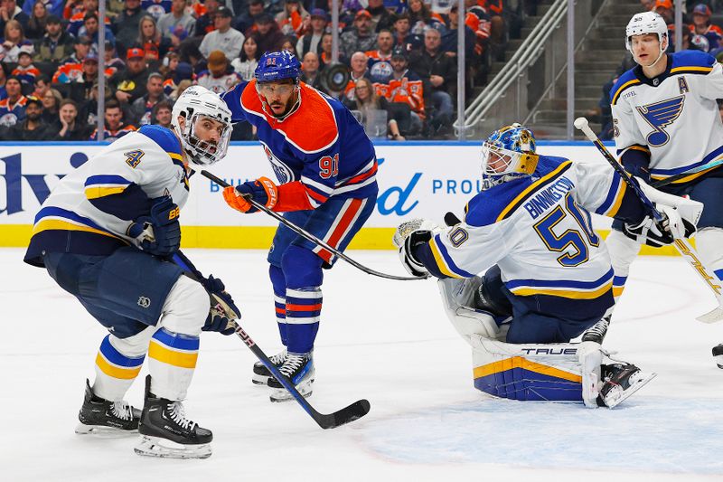 Feb 28, 2024; Edmonton, Alberta, CAN; Edmonton Oilers forward Evander Kane (91), St. Louis Blues defensemen Nick Leddy (4) and goaltender Jordan Binnington (50) try to find a loose puck during the third period at Rogers Place. Mandatory Credit: Perry Nelson-USA TODAY Sports