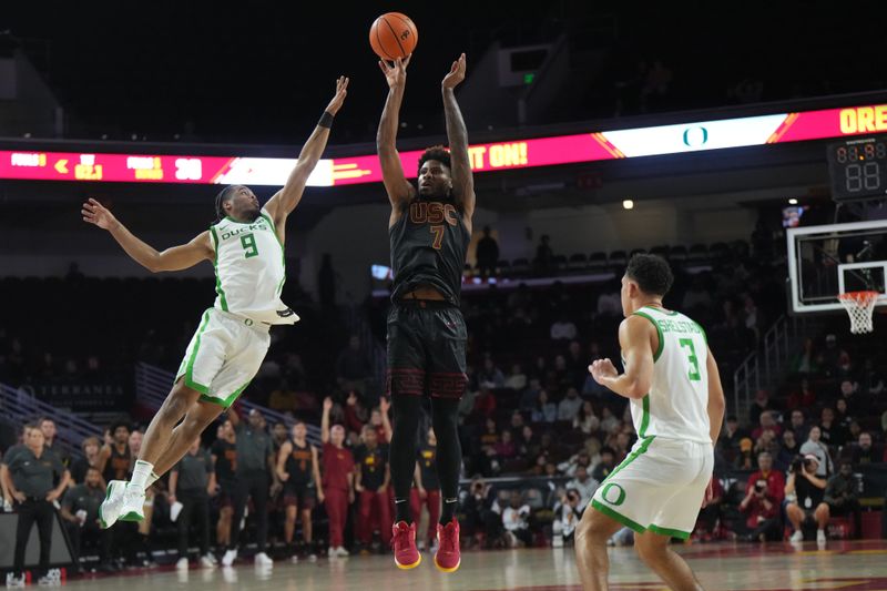 Dec 4, 2024; Los Angeles, California, USA; Southern California Trojans guard Chibuzo Agbo (7) shoots against Oregon Ducks guard Keeshawn Barthelemy (9) in the first half at Galen Center. Mandatory Credit: Kirby Lee-Imagn Images