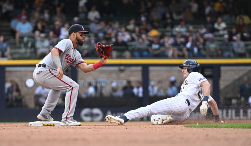 Sep 17, 2023; Milwaukee, Wisconsin, USA; Milwaukee Brewers left fielder Mark Canha (21) slides in safely ahead of the tag by Washington Nationals second baseman Luis Garcia (2) in the sixth inning at American Family Field. Mandatory Credit: Michael McLoone-USA TODAY Sports