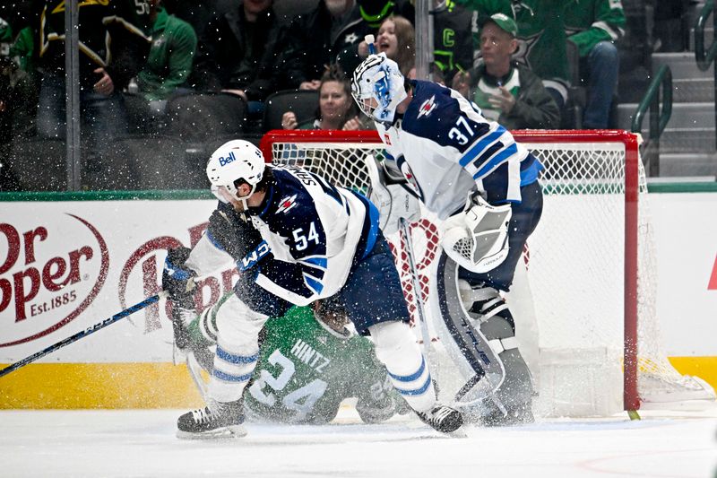 Feb 29, 2024; Dallas, Texas, USA; Winnipeg Jets defenseman Dylan Samberg (54) is called for a penalty as he takes down Dallas Stars center Roope Hintz (24) in front of Jets goaltender Connor Hellebuyck (37) during the third period at the American Airlines Center. Mandatory Credit: Jerome Miron-USA TODAY Sports