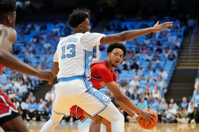 Nov 6, 2023; Chapel Hill, North Carolina, USA; Radford Highlanders center D'Auntray Pierce (21) looks to pass as North Carolina Tar Heels forward Jalen Washington (13) defends in the first half at Dean E. Smith Center. Mandatory Credit: Bob Donnan-USA TODAY Sports