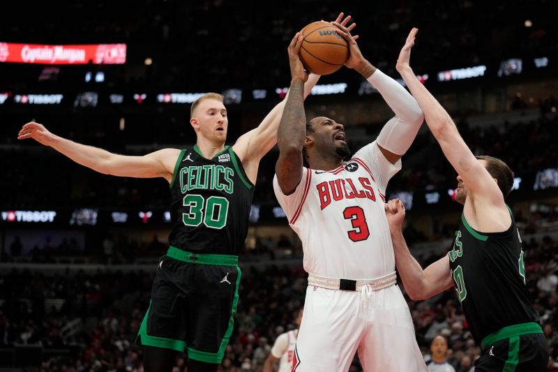 CHICAGO, ILLINOIS - FEBRUARY 22: Andre Drummond #3 of the Chicago Bulls goes to the basket against Sam Hauser #30 and Luke Kornet #40 of the Boston Celticsduring the second half at the United Center on February 22, 2024 in Chicago, Illinois. NOTE TO USER: User expressly acknowledges and agrees that, by downloading and or using this photograph, User is consenting to the terms and conditions of the Getty Images License Agreement. (Photo by Patrick McDermott/Getty Images)