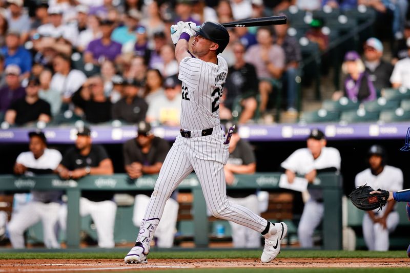 Jun 18, 2024; Denver, Colorado, USA; Colorado Rockies left fielder Nolan Jones (22) hits a sacrifice fly RBI in the first inning against the Los Angeles Dodgers at Coors Field. Mandatory Credit: Isaiah J. Downing-USA TODAY Sports