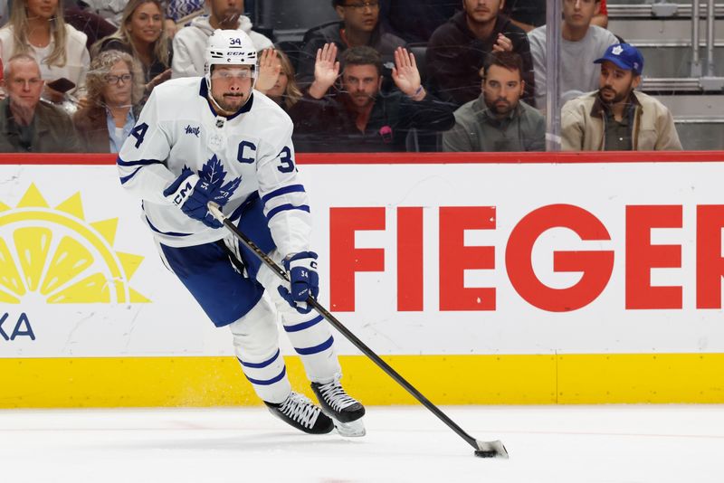 Oct 11, 2025; Detroit, Michigan, USA;  Toronto Maple Leafs center Auston Matthews (34) skates with the puck in the third period against the Detroit Red Wings at Little Caesars Arena. Mandatory Credit: Rick Osentoski-Imagn Images