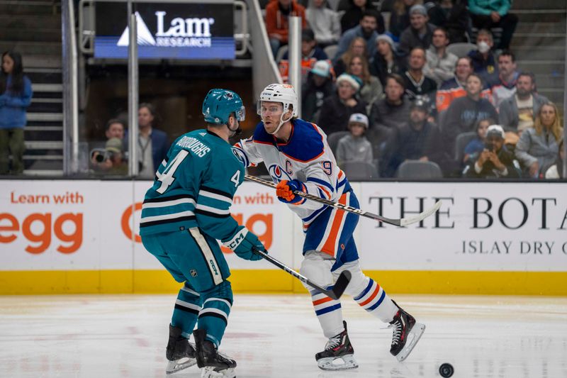 Dec 28, 2023; San Jose, California, USA; Edmonton Oilers center Connor McDavid (97) checks San Jose Sharks defenseman Kyle Burroughs (4) to dislodge the puck during the first period at SAP Center at San Jose. Mandatory Credit: Neville E. Guard-USA TODAY Sports