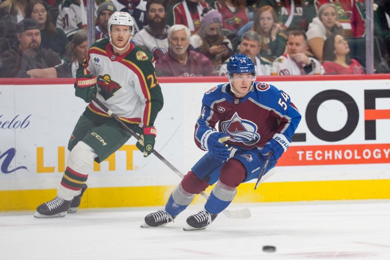 Dec 21, 2025; Saint Paul, Minnesota, USA; Colorado Avalanche center Gavin Brindley (54) skates with the puck after separating from Minnesota Wild defenseman Jonas Brodin (25) in the first period at Grand Casino Arena. Mandatory Credit: Matt Blewett-Imagn Images