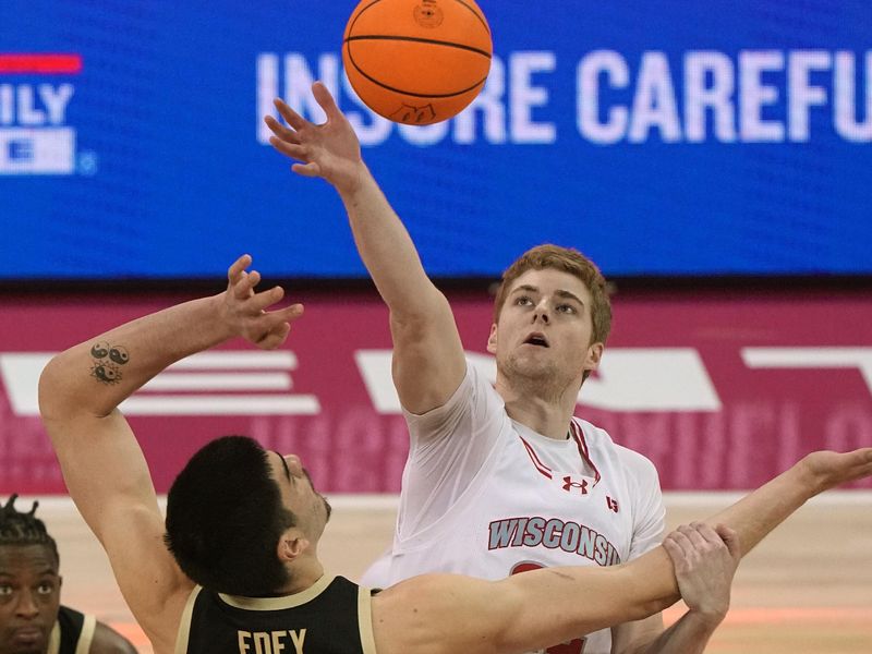 Feb 4, 2024; Madison, Wisconsin, USA; Wisconsin's Steven Crowl (22) wins the opening tipoff against Purdue center Zach Edey (15) during the first half at Kohl Center. Mandatory Credit: Mark Hoffman-USA TODAY Sports