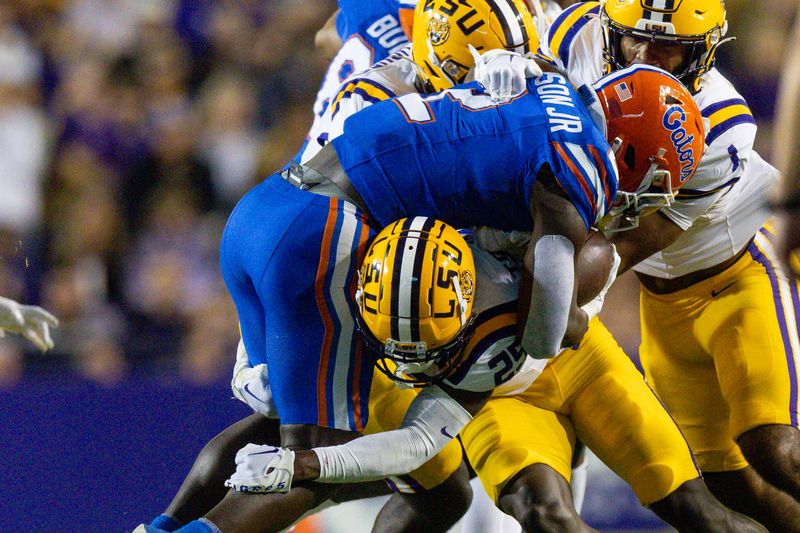 Nov 11, 2023; Baton Rouge, Louisiana, USA;  Florida Gators running back Montrell Johnson Jr. (2) is tackled by LSU Tigers safety Javien Toviano (25) during the first half at Tiger Stadium. Mandatory Credit: Stephen Lew-USA TODAY Sports