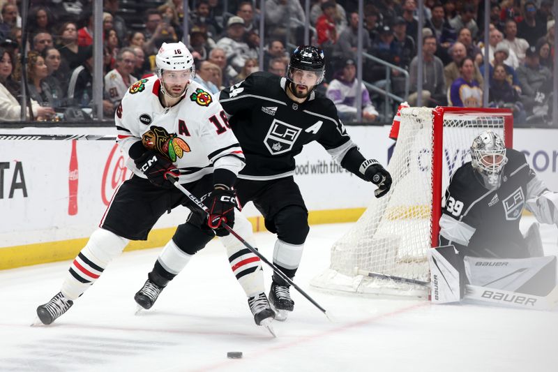 Mar 19, 2024; Los Angeles, California, USA;  Chicago Blackhawks center Jason Dickinson (16) controls the puck against Los Angeles Kings center Phillip Danault (24) during the second period at Crypto.com Arena. Mandatory Credit: Kiyoshi Mio-USA TODAY Sports