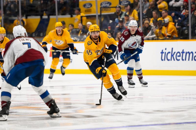 Nov 2, 2024; Nashville, Tennessee, USA;  Nashville Predators defenseman Alexandre Carrier (45) skates with the puck against the Colorado Avalanche during the third period at Bridgestone Arena. Mandatory Credit: Steve Roberts-Imagn Images