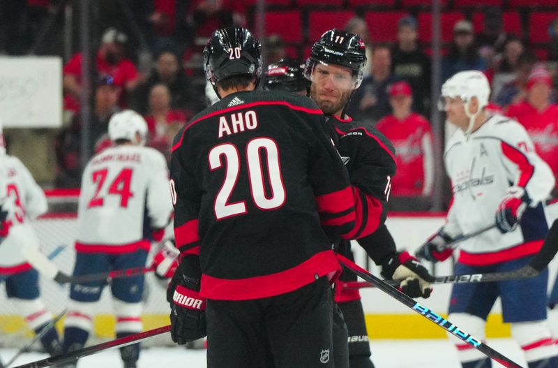 Apr 5, 2024; Raleigh, North Carolina, USA; Carolina Hurricanes center Jordan Staal (11) and center Sebastian Aho (20) play around during the warmups before the game against the Washington Capitals at PNC Arena. Mandatory Credit: James Guillory-USA TODAY Sports