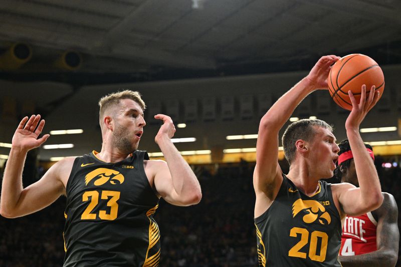 Feb 2, 2024; Iowa City, Iowa, USA; Iowa Hawkeyes forward Ben Krikke (23) and forward Payton Sandfort (20) react to a call during the first half against the Ohio State Buckeyes at Carver-Hawkeye Arena. Mandatory Credit: Jeffrey Becker-USA TODAY Sports