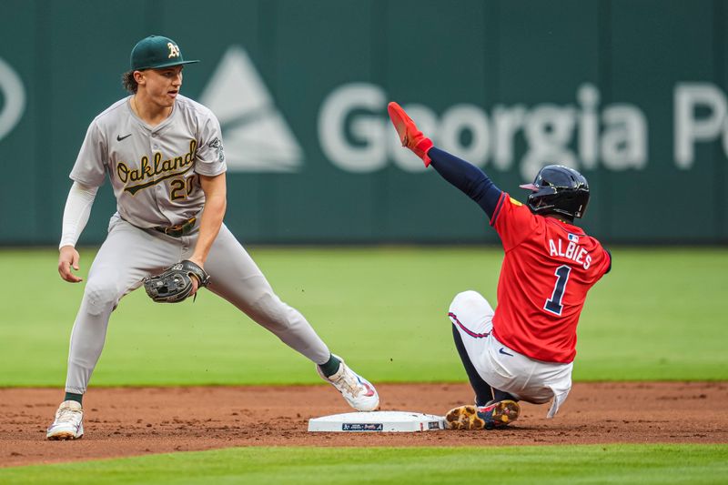 May 31, 2024; Cumberland, Georgia, USA; Oakland Athletics second baseman Zack Gelof (20) forces out Atlanta Braves second baseman Ozzie Albies (1) during the first inning at Truist Park. Mandatory Credit: Dale Zanine-USA TODAY Sports