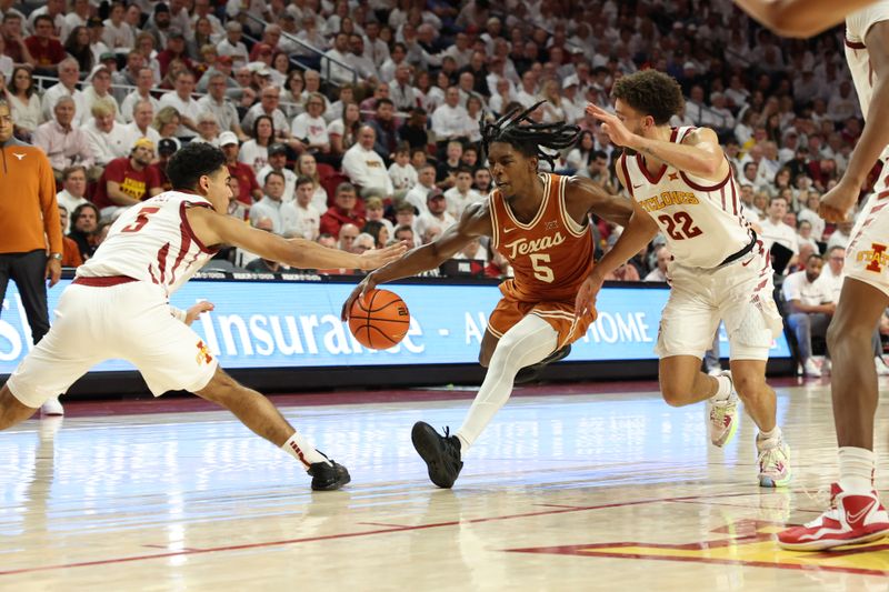 Jan 17, 2023; Ames, Iowa, USA; Texas Longhorns guard Marcus Carr (5) is defended by Iowa State Cyclones forward Aljaz Kunc (5) and guard Gabe Kalscheur (22) during the second half at James H. Hilton Coliseum. Mandatory Credit: Reese Strickland-USA TODAY Sports