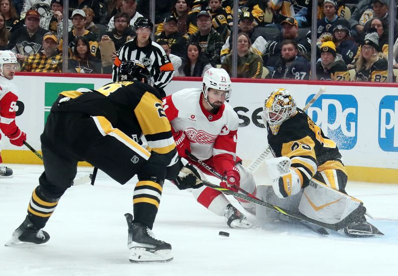 Nov 13, 2024; Pittsburgh, Pennsylvania, USA;  Pittsburgh Penguins defenseman Matt Grzelcyk (24) and goaltender Alex Nedeljkovic (39) defend Detroit Red Wings center Dylan Larkin (71) during the second period at PPG Paints Arena. Mandatory Credit: Charles LeClaire-Imagn Images