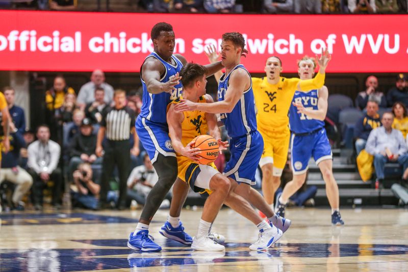 Feb 3, 2024; Morgantown, West Virginia, USA; Brigham Young Cougars forward Fousseyni Traore (45) and Brigham Young Cougars guard Trevin Knell (21) defend West Virginia Mountaineers guard Kerr Kriisa (3) during the first half at WVU Coliseum. Mandatory Credit: Ben Queen-USA TODAY Sports