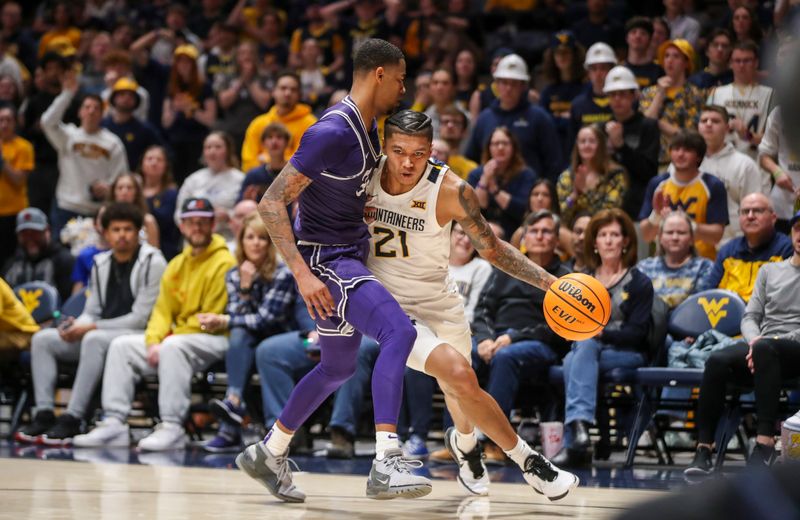 Mar 6, 2024; Morgantown, West Virginia, USA; West Virginia Mountaineers guard RaeQuan Battle (21) drives against TCU Horned Frogs guard Avery Anderson III (3) during the second half at WVU Coliseum. Mandatory Credit: Ben Queen-USA TODAY Sports