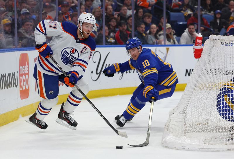 Mar 9, 2024; Buffalo, New York, USA;  Edmonton Oilers center Connor McDavid (97) plays the puck behind the net as Buffalo Sabres defenseman Henri Jokiharju (10) tries to defend during the first period at KeyBank Center. Mandatory Credit: Timothy T. Ludwig-USA TODAY Sports