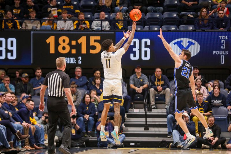 Feb 11, 2025; Morgantown, West Virginia, USA; West Virginia Mountaineers guard Jonathan Powell (11) shoots a three pointer over Brigham Young Cougars guard Trevin Knell (21) during the second half at WVU Coliseum. Mandatory Credit: Ben Queen-Imagn Images