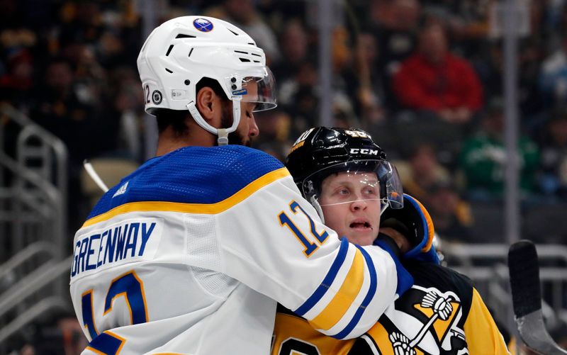 Jan 6, 2024; Pittsburgh, Pennsylvania, USA;  Buffalo Sabres left wing Jordan Greenway (12) puts Pittsburgh Penguins right wing Valtteri Puustinen (48) in a headlock to clear him from the Sabres net during the first period at PPG Paints Arena. Mandatory Credit: Charles LeClaire-USA TODAY Sports