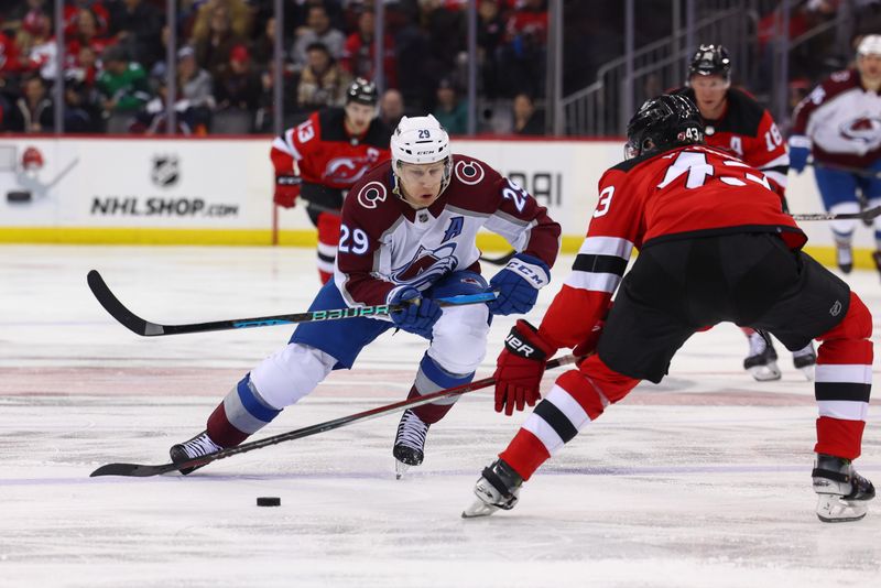 Feb 6, 2024; Newark, New Jersey, USA; Colorado Avalanche center Nathan MacKinnon (29) skates with the puck while being defended by New Jersey Devils defenseman Luke Hughes (43) during the third period at Prudential Center. Mandatory Credit: Ed Mulholland-USA TODAY Sports