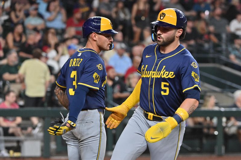 Apr 11, 2025; Phoenix, Arizona, USA; Milwaukee Brewers third base Joey Ortiz (3)and outfielder Garrett Mitchell (5) celebrate after scoring in the ninth inning against the Arizona Diamondbacks at Chase Field. Mandatory Credit: Matt Kartozian-Imagn Images