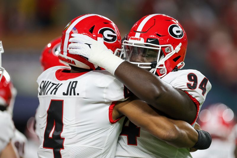 Dec 31, 2021; Miami Gardens, Florida, USA; Georgia Bulldogs defensive lineman Jonathan Jefferson (94) and linebacker Nolan Smith (4) embrace prior the game against the Michigan Wolverines during the Orange Bowl college football CFP national semifinal game at Hard Rock Stadium. Mandatory Credit: Sam Navarro-USA TODAY Sports