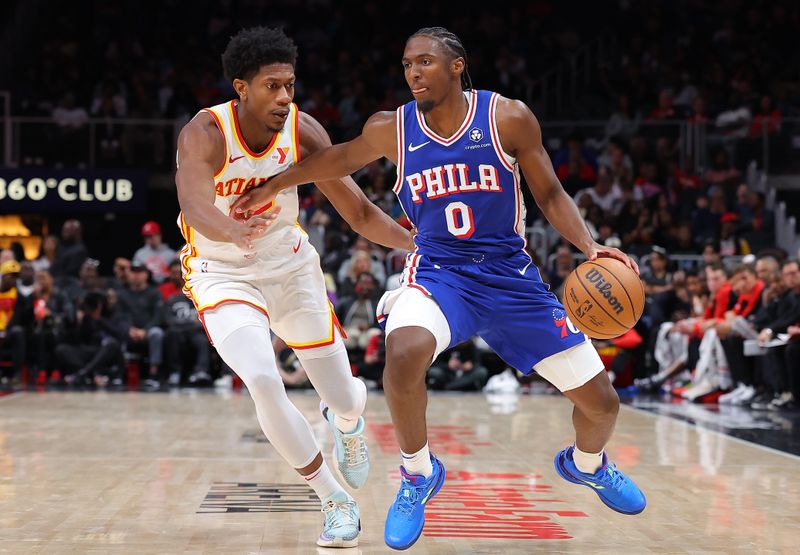 ATLANTA, GEORGIA - OCTOBER 14:  Tyrese Maxey #0 of the Philadelphia 76ers drives against De'Andre Hunter #12 of the Atlanta Hawks during the second quarter at State Farm Arena on October 14, 2024 in Atlanta, Georgia.  NOTE TO USER: User expressly acknowledges and agrees that, by downloading and/or using this photograph, user is consenting to the terms and conditions of the Getty Images License Agreement.  (Photo by Kevin C. Cox/Getty Images)