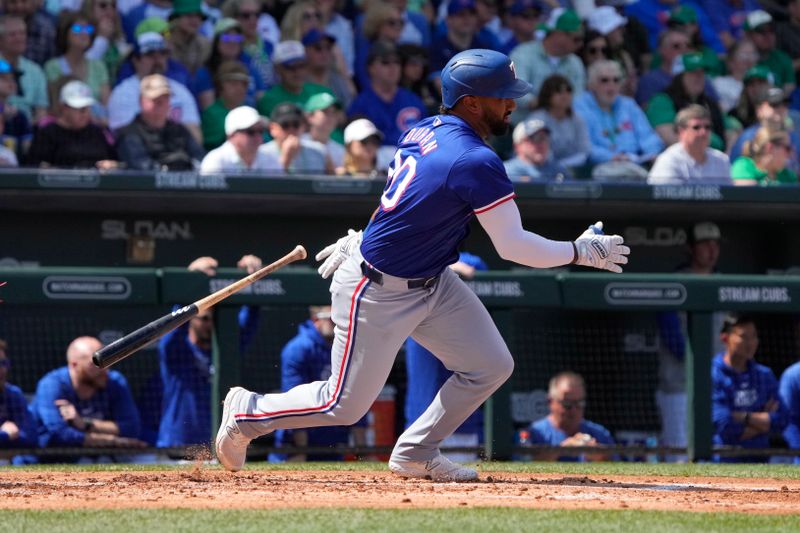 Mar 17, 2024; Mesa, Arizona, USA; Texas Rangers shortstop Ezequiel Duran (20) hits against the Chicago Cubs in the second inning at Sloan Park. Mandatory Credit: Rick Scuteri-USA TODAY Sports