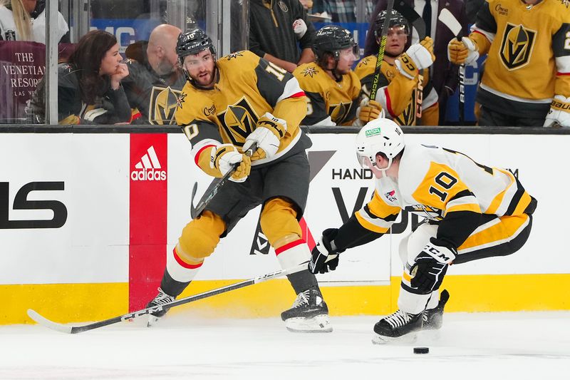 Jan 20, 2024; Las Vegas, Nevada, USA; Vegas Golden Knights center Nicolas Roy (10) passes the puck away from \Pittsburgh Penguins left wing Drew O'Connor (10) during the first period at T-Mobile Arena. Mandatory Credit: Stephen R. Sylvanie-USA TODAY Sports