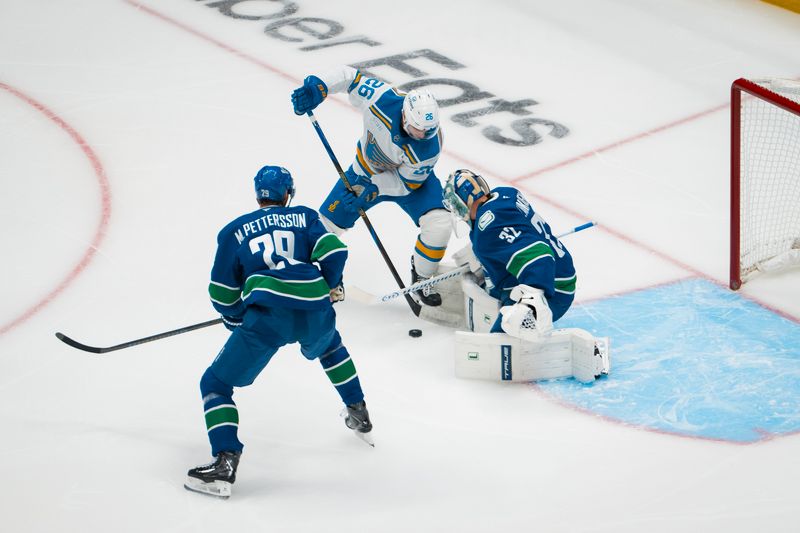 Oct 13, 2025; Vancouver, British Columbia, CAN; Vancouver Canucks defenseman Marcus Pettersson (29) watches as goalie Kevin Lankinen (32) makes a save on St. Louis Blues forward Nathan Walker (26) in the first period at Rogers Arena. Mandatory Credit: Bob Frid-Imagn Images