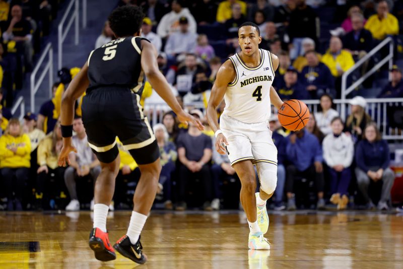 Feb 11, 2025; Ann Arbor, Michigan, USA;  Michigan Wolverines guard Nimari Burnett (4) dribbles against Purdue Boilermakers guard Myles Colvin (5) in the first half at Crisler Center. Mandatory Credit: Rick Osentoski-Imagn Images