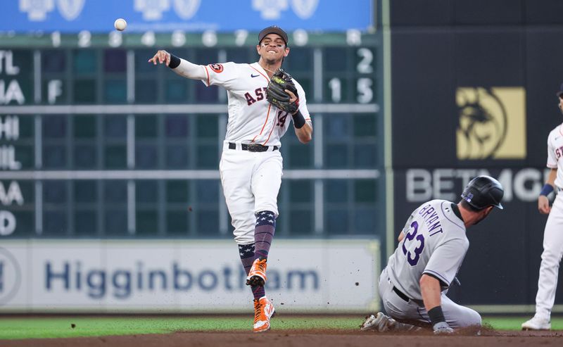 Jul 4, 2023; Houston, Texas, USA; Colorado Rockies designated hitter Kris Bryant (23) is out and Houston Astros second baseman Mauricio Dubon (14) throws to first base to complete a double play during the first inning at Minute Maid Park. Mandatory Credit: Troy Taormina-USA TODAY Sports