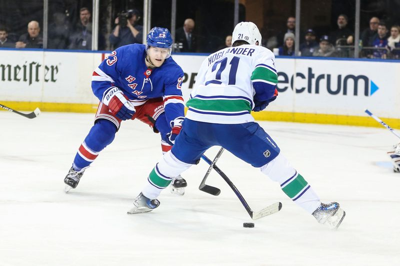 Jan 8, 2024; New York, New York, USA;  New York Rangers defenseman Adam Fox (23) and Vancouver Canucks left wing Nils Hoglander (21) battle for control of the puck in the second period at Madison Square Garden. Mandatory Credit: Wendell Cruz-USA TODAY Sports