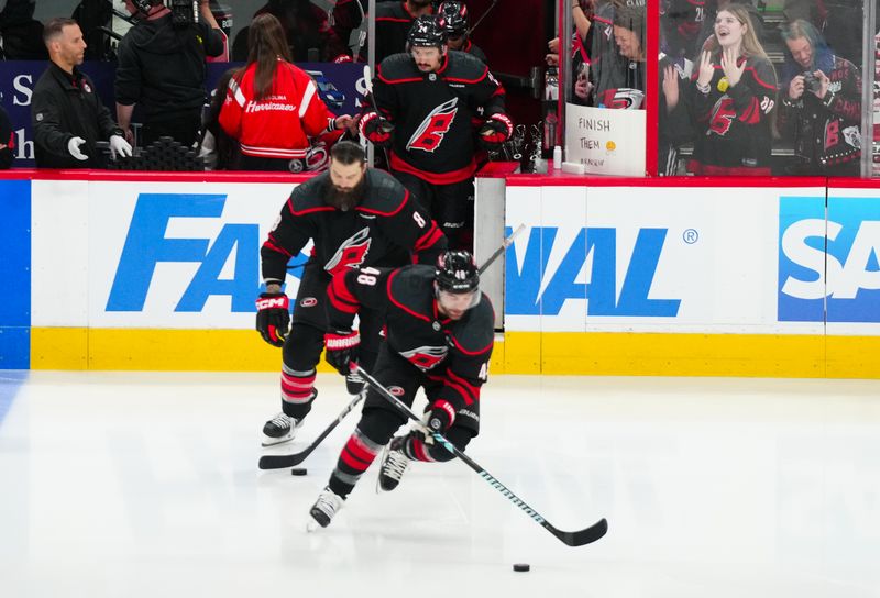 Apr 29, 2025; Raleigh, North Carolina, USA; Carolina Hurricanes left wing Jordan Martinook (48) defenseman Brent Burns (8) and center Seth Jarvis (24)  skate out onto the ice from the warmups before the game against the New Jersey Devils in game five of the first round of the 2025 Stanley Cup Playoffs at Lenovo Center. Mandatory Credit: James Guillory-Imagn Images