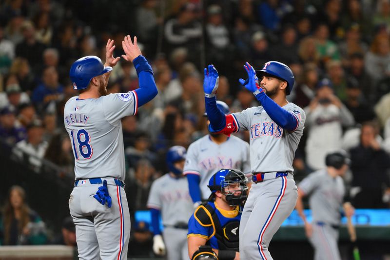 Sep 14, 2024; Seattle, Washington, USA; Texas Rangers catcher Carson Kelly (18) and center fielder Leody Taveras (3) celebrate after Taveras hit a 2-run home run against the Seattle Mariners during the third inning at T-Mobile Park. Mandatory Credit: Steven Bisig-Imagn Images