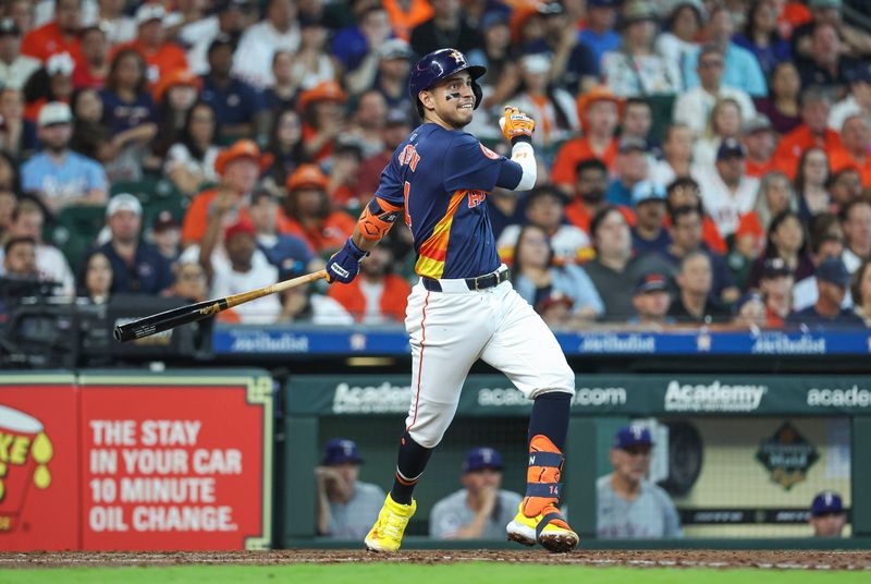 Apr 14, 2024; Houston, Texas, USA; Houston Astros third baseman Mauricio Dubon (14) hits an RBI double during the fourth inning against the Texas Rangers at Minute Maid Park. Mandatory Credit: Troy Taormina-USA TODAY Sports