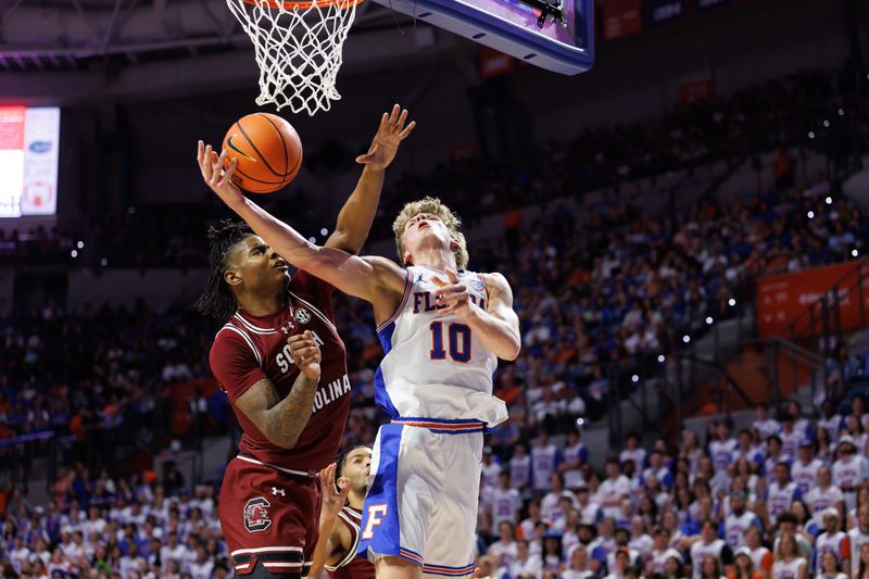 Feb 15, 2025; Gainesville, Florida, USA; Florida Gators forward Thomas Haugh (10) attempts a layup over South Carolina Gamecocks forward Collin Murray-Boyles (30) during the second half at Exactech Arena at the Stephen C. O'Connell Center. Mandatory Credit: Matt Pendleton-Imagn Images