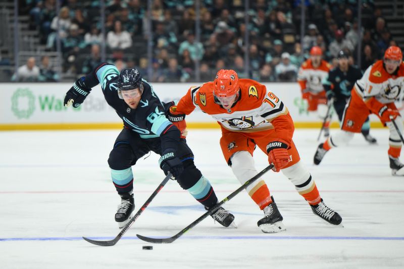 Oct 9, 2025; Seattle, Washington, USA; Seattle Kraken defenseman Brandon Montour (62) and Anaheim Ducks right wing Troy Terry (19) play the puck during the second period at Climate Pledge Arena. Mandatory Credit: Steven Bisig-Imagn Images