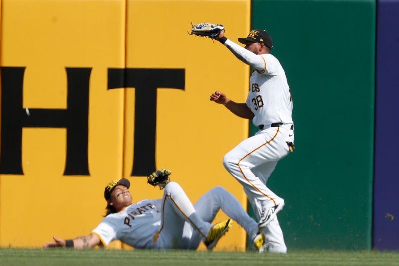 May 25, 2024; Pittsburgh, Pennsylvania, USA;  Pittsburgh Pirates right fielder Edward Olivares (38) makes a catch for an out on a ball hit by Atlanta Braves first baseman Matt Olson (not pictured) as center fielder Ji Hwan Bae (left) avoids a collision during the first inning at PNC Park. Mandatory Credit: Charles LeClaire-USA TODAY Sports